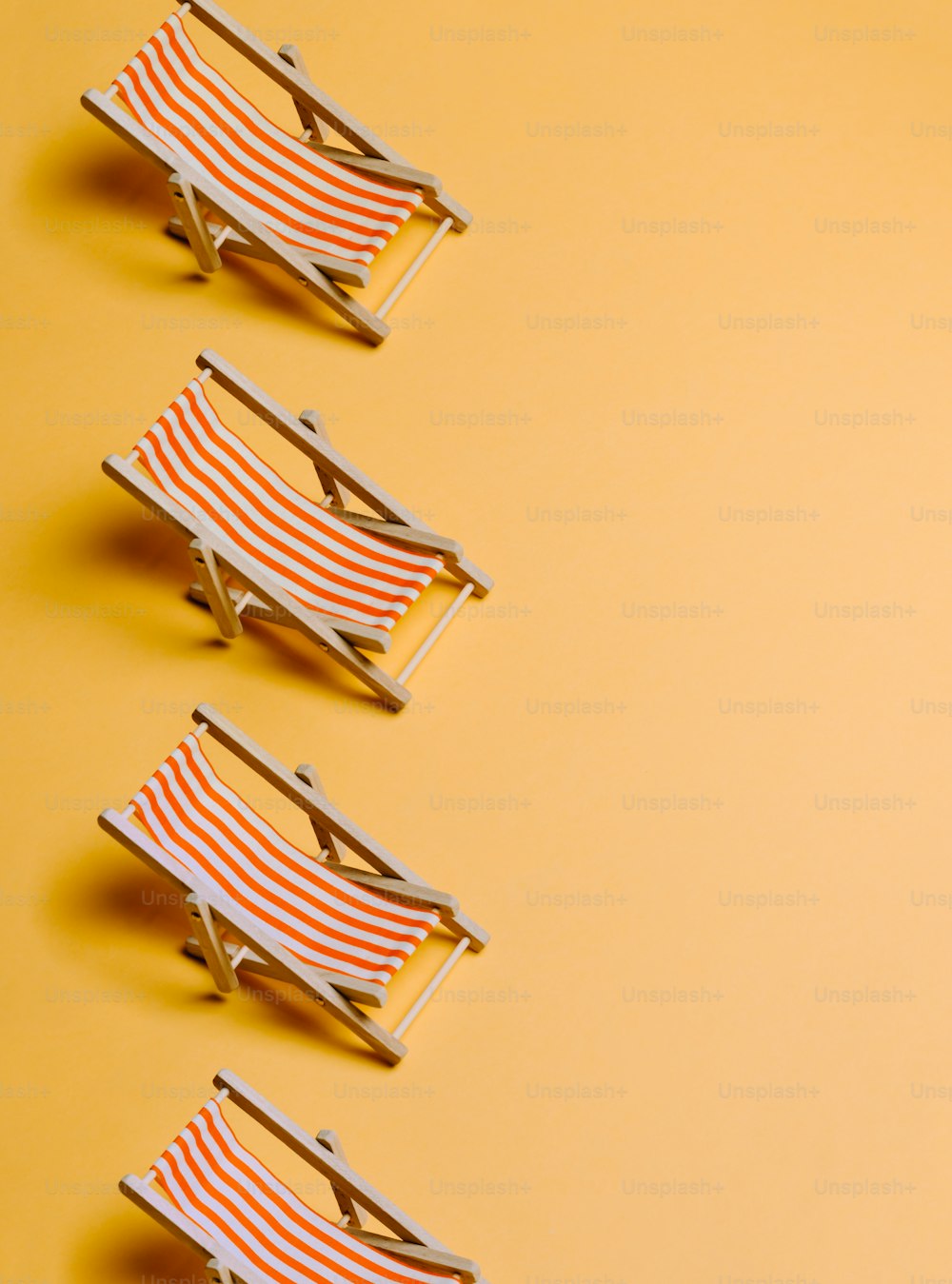 a row of beach chairs sitting on top of a yellow background
