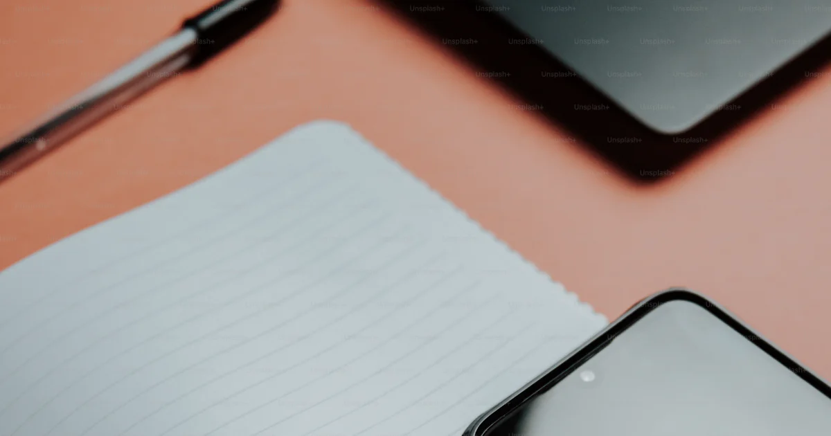 Notebook Open. Phone A cell phone sitting on top of a notebook next to a pen photo – Cell ...