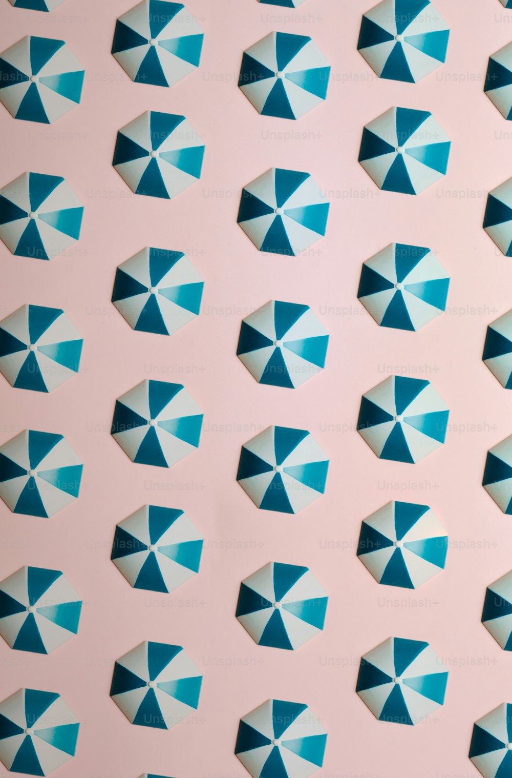 a pattern of blue and white umbrellas on a pink background
