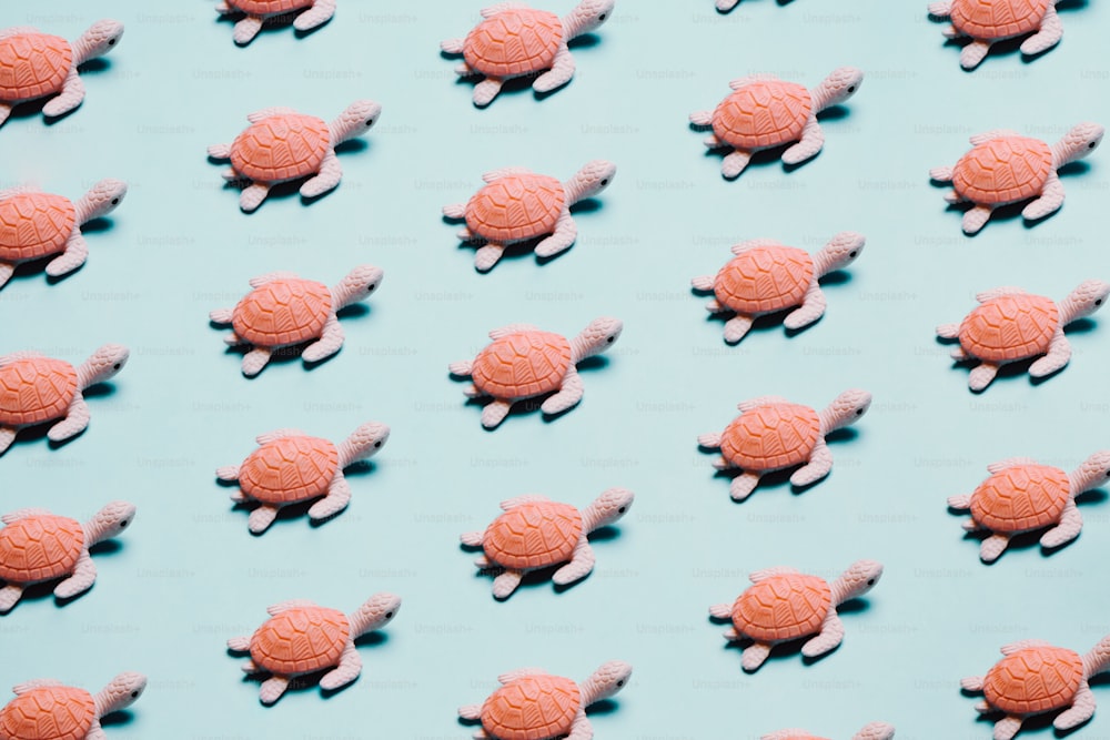um grande grupo de pequenas tartarugas cor-de-rosa em um fundo azul