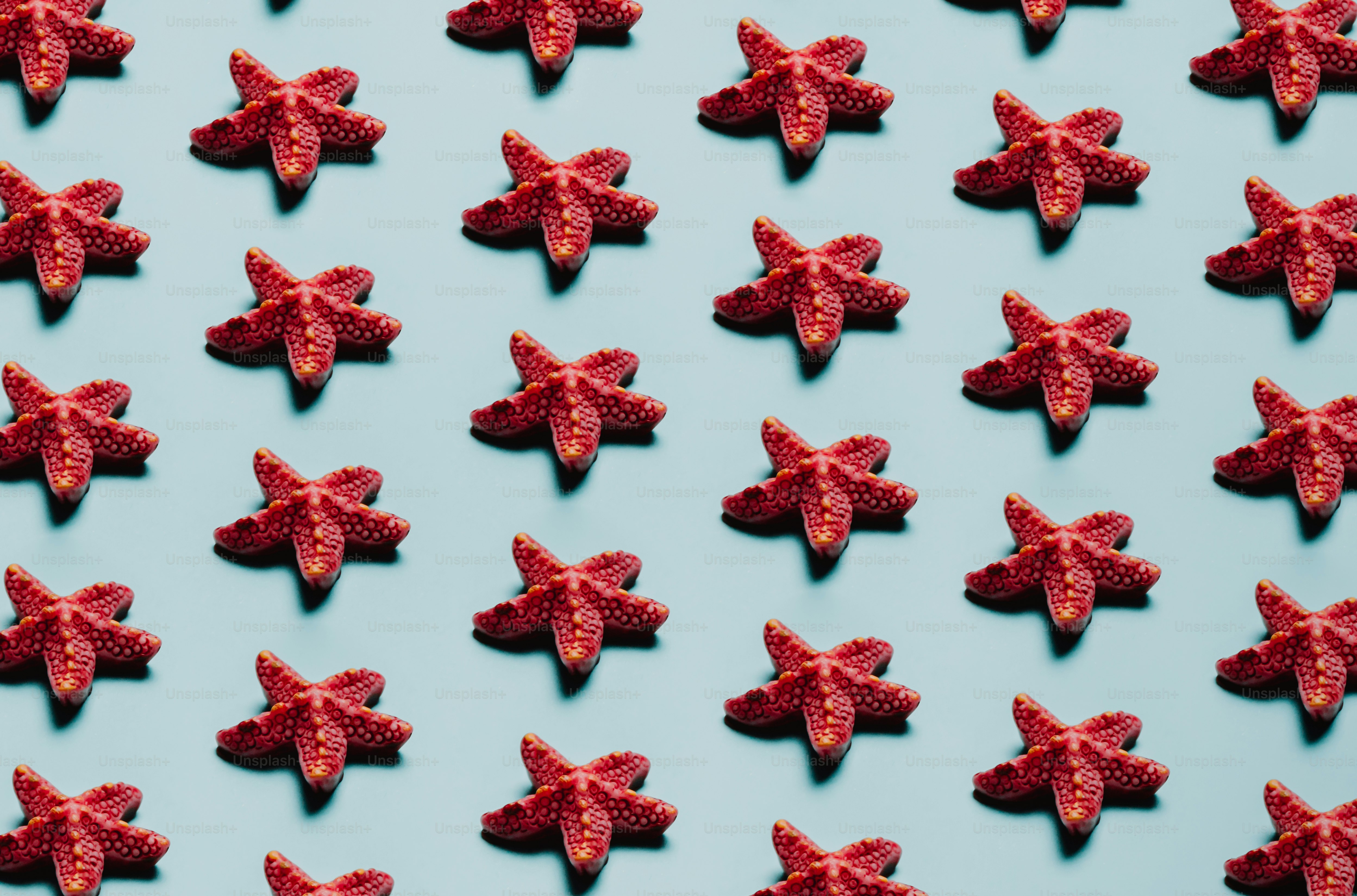 um grupo de doces vermelhos em uma superfície azul