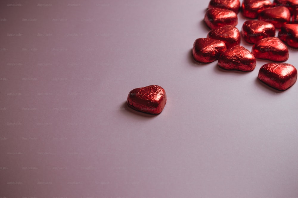 a pile of heart shaped chocolates sitting on top of a table