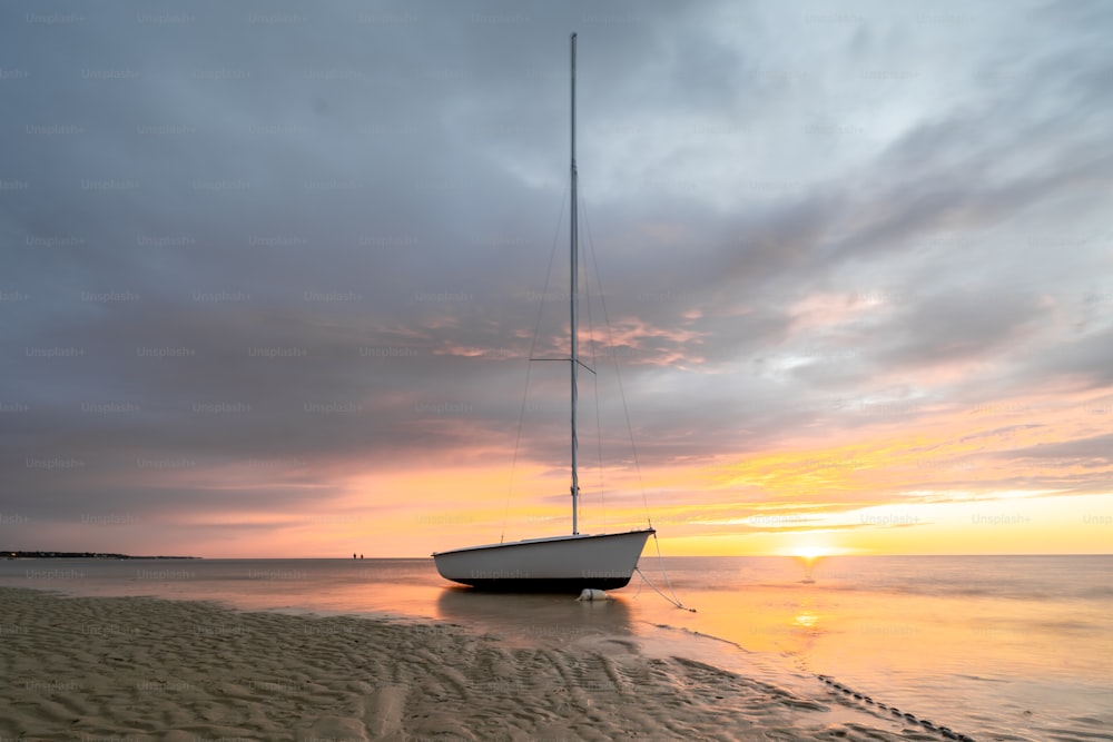 um veleiro sentado em cima de uma praia de areia