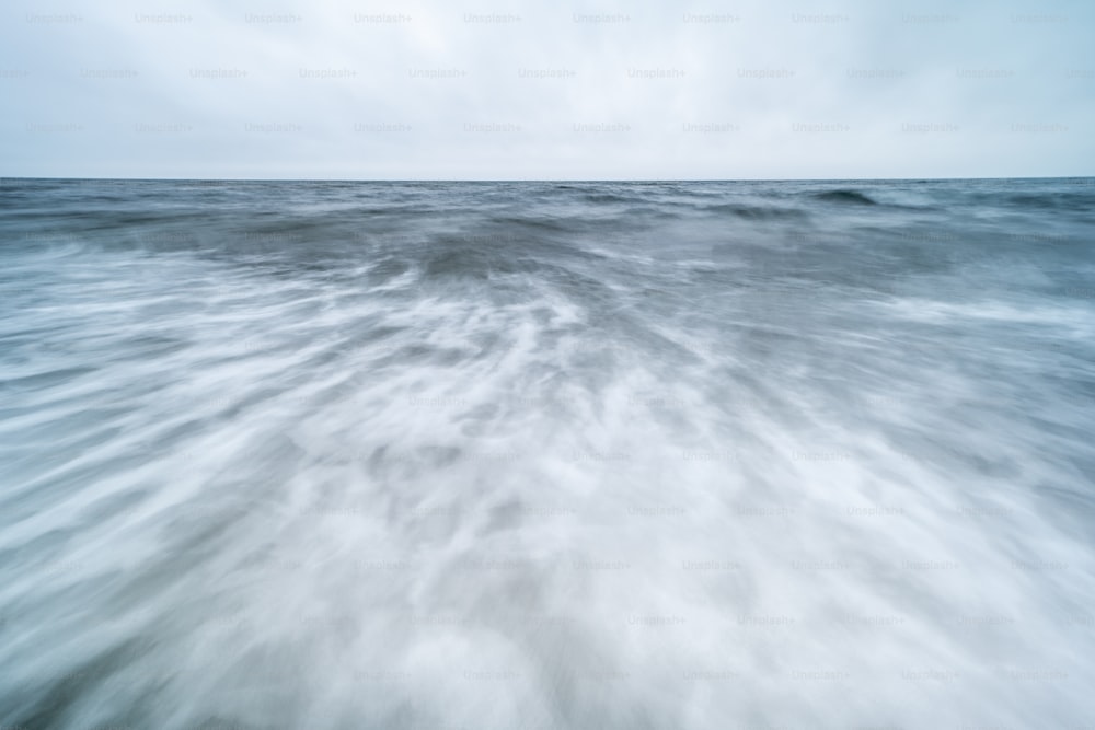 a large body of water with a sky in the background