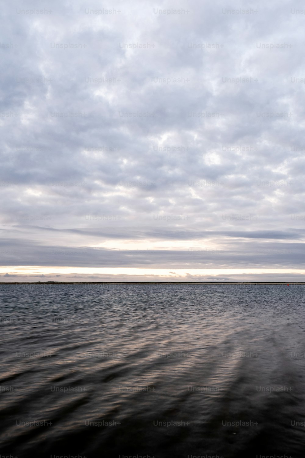 a large body of water under a cloudy sky