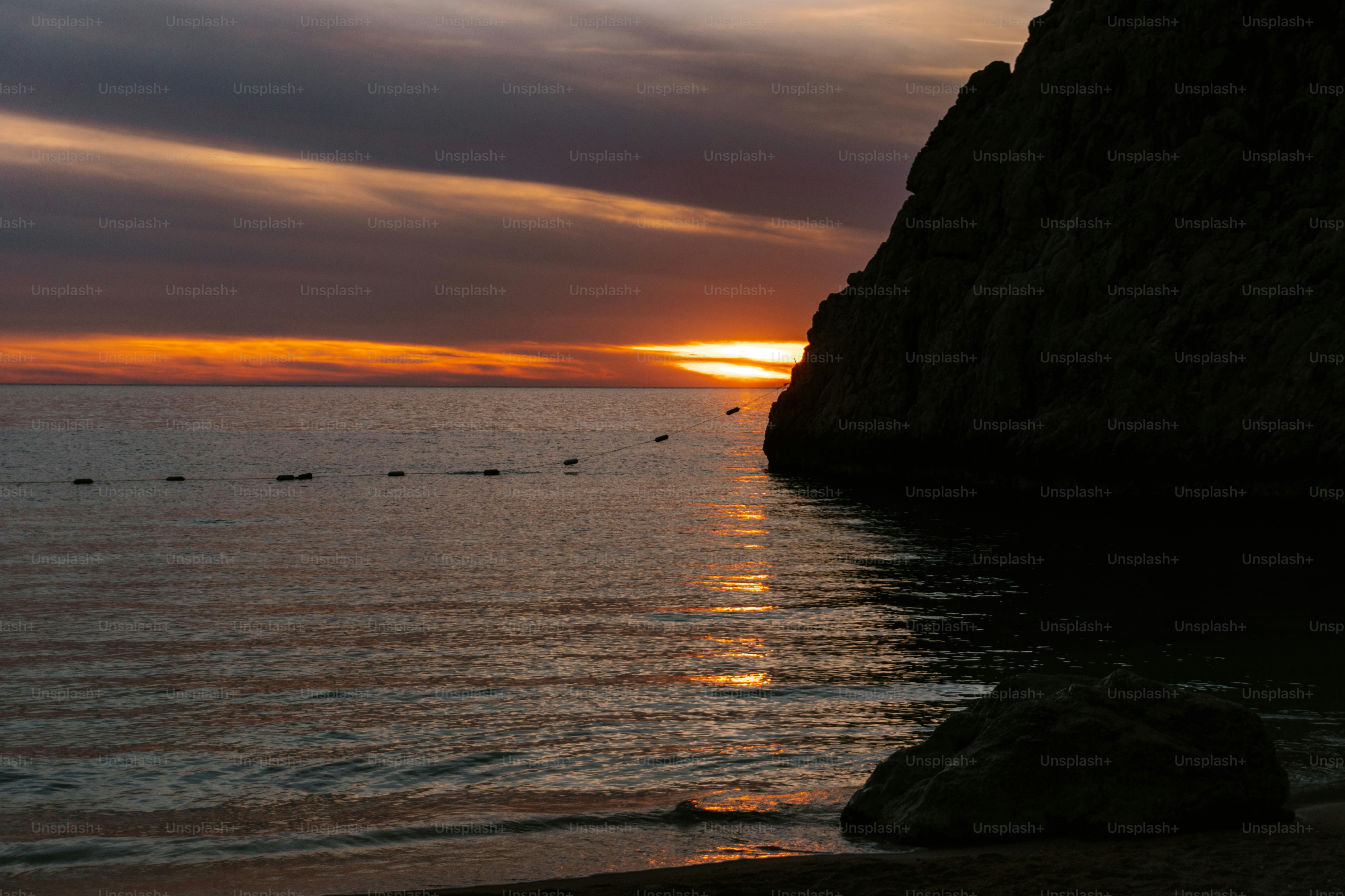 the sun is setting over the water at the beach