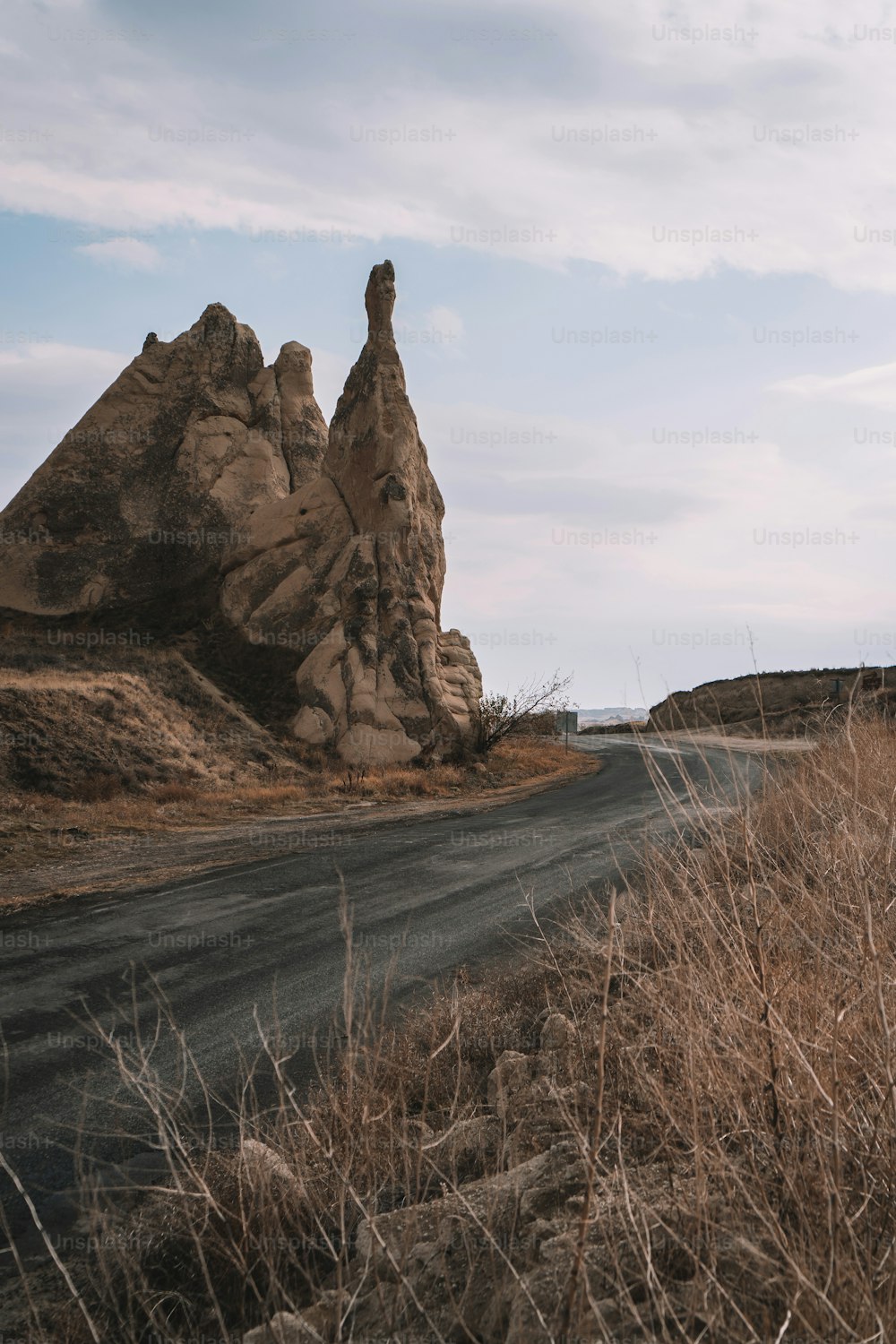 a dirt road near a large rock formation