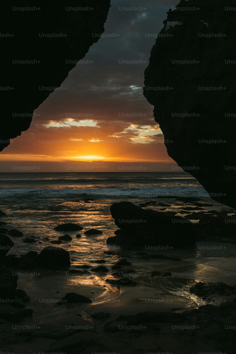 a view of a sunset through a cave