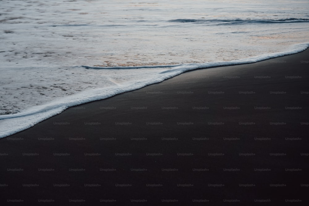 Una spiaggia nera con onde che arrivano a riva