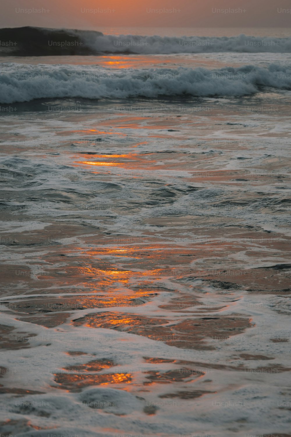 the sun is setting over the ocean waves