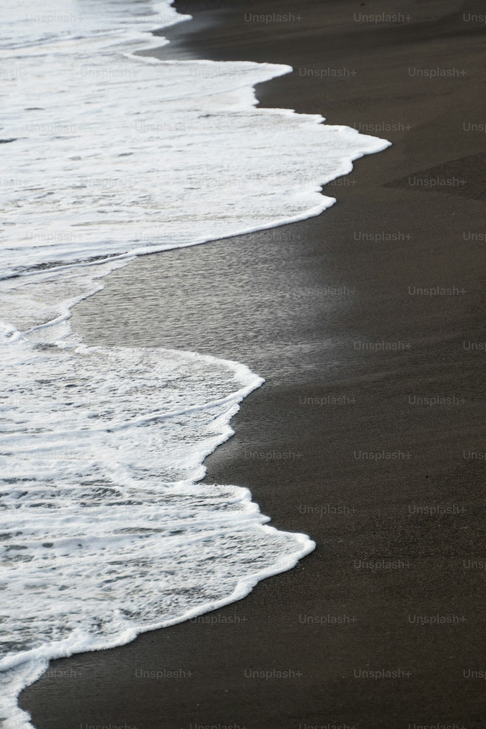 eine Person, die an einem Strand am Meer entlang geht