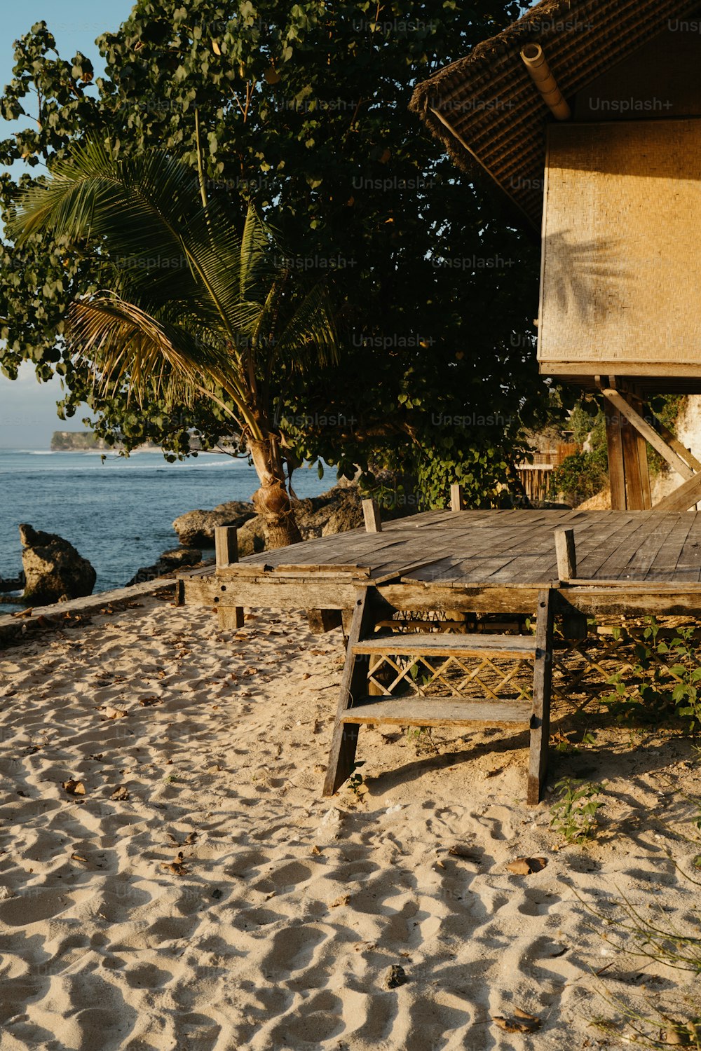 un banco de madera sentado en la parte superior de una playa de arena