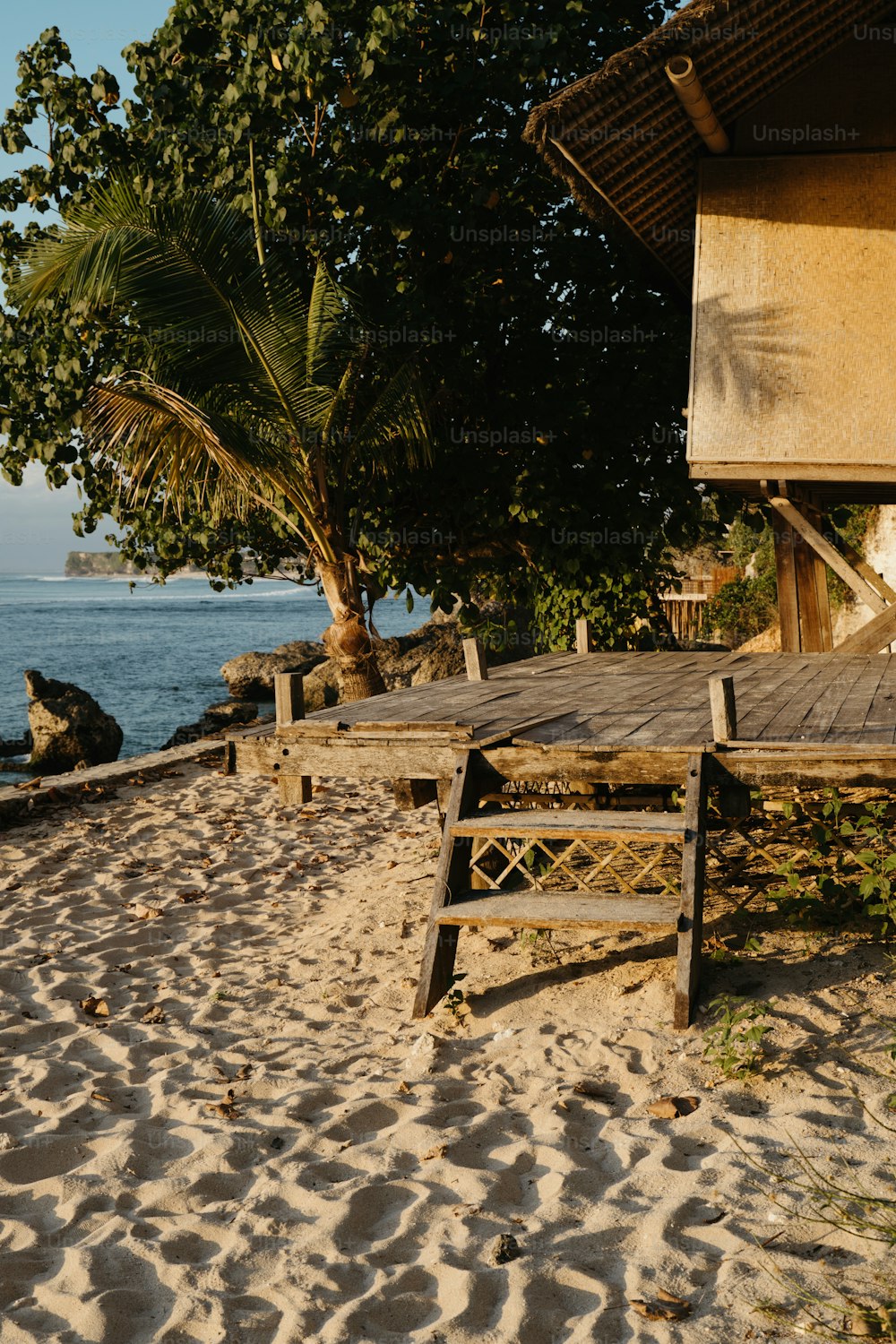 a wooden bench sitting on top of a sandy beach