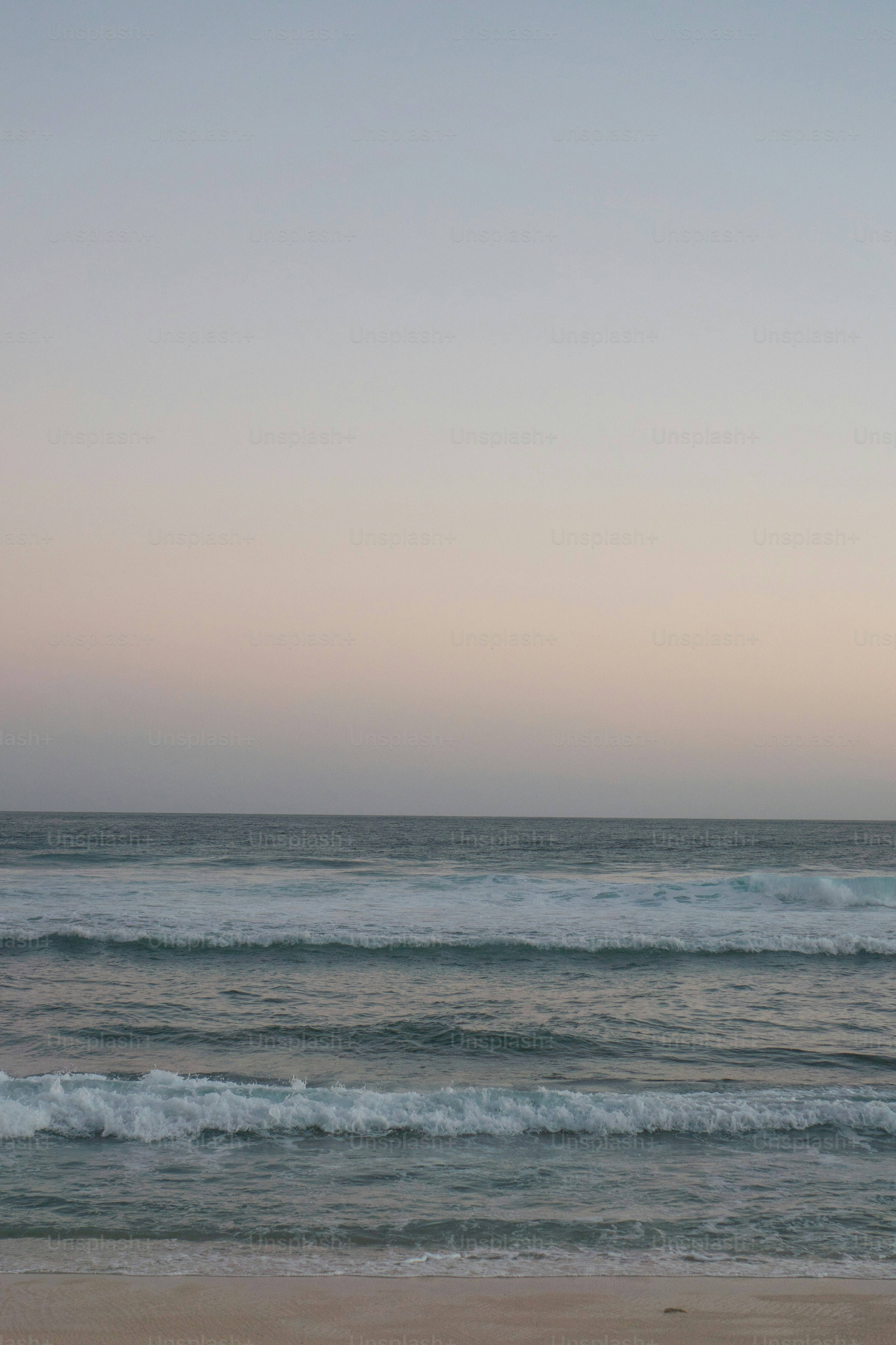 una persona che cavalca una tavola da surf in cima a una spiaggia sabbiosa