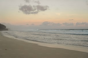 a sandy beach with waves coming in to shore