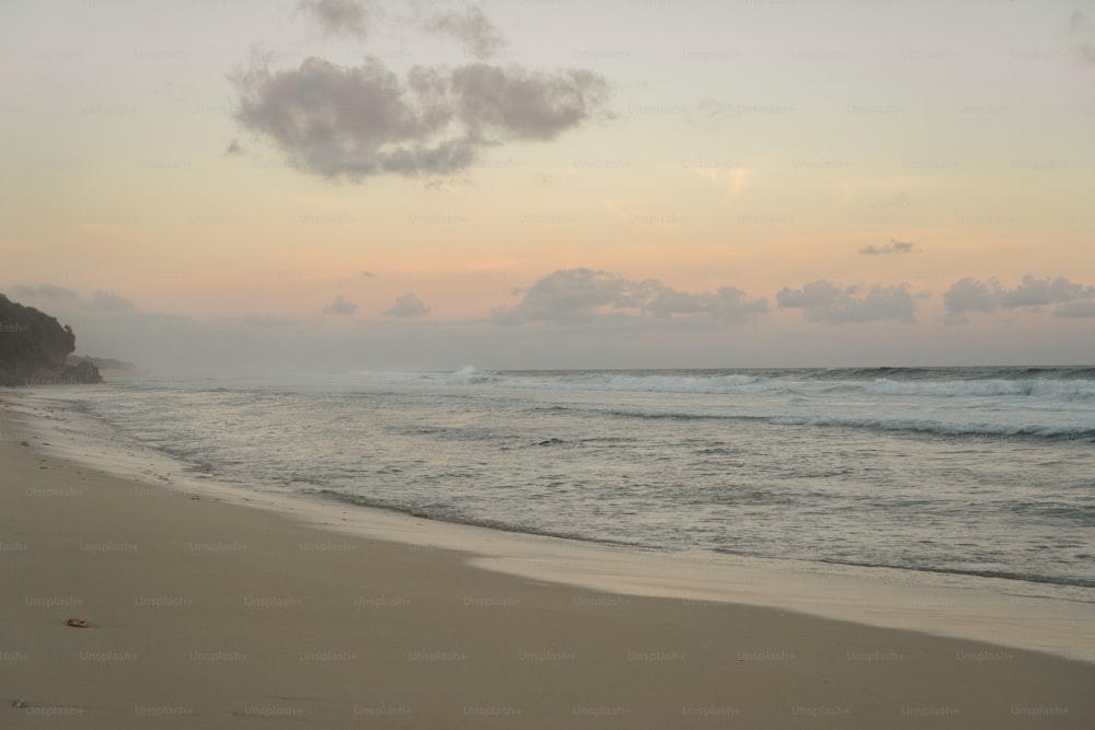 une plage de sable avec des vagues qui arrivent sur le rivage