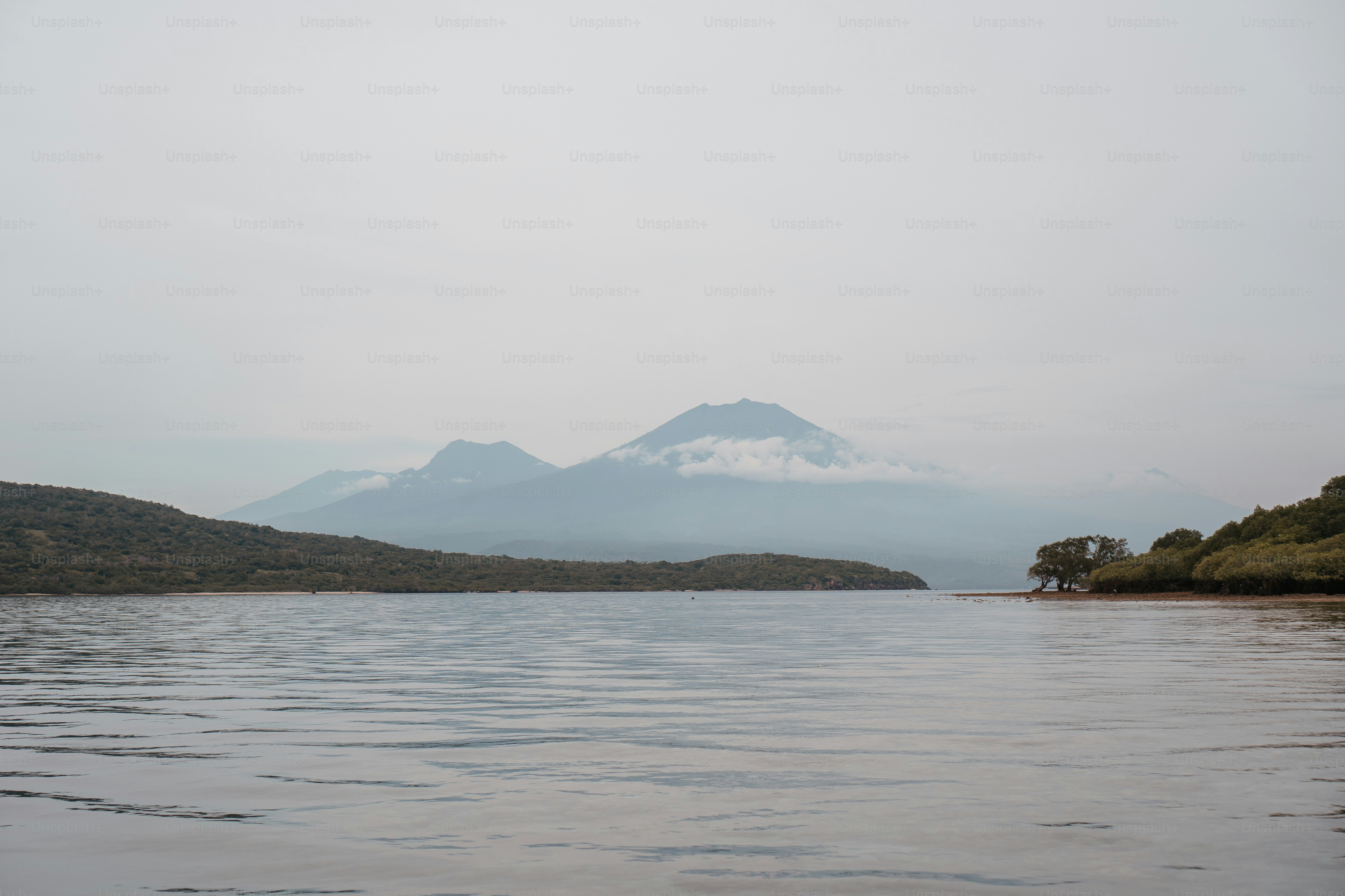 a large body of water with a mountain in the background