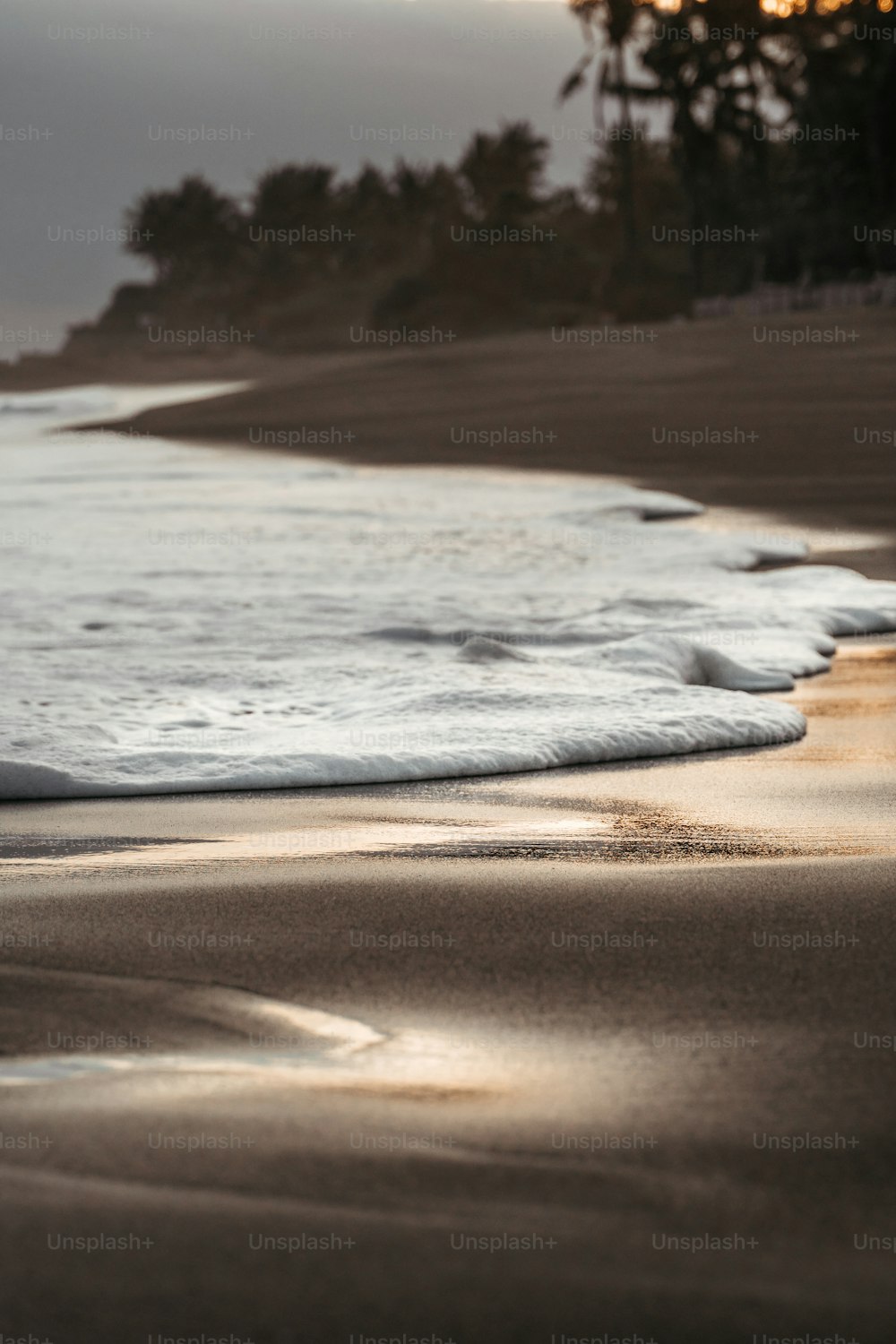 une plage avec des vagues qui entrent sur le rivage