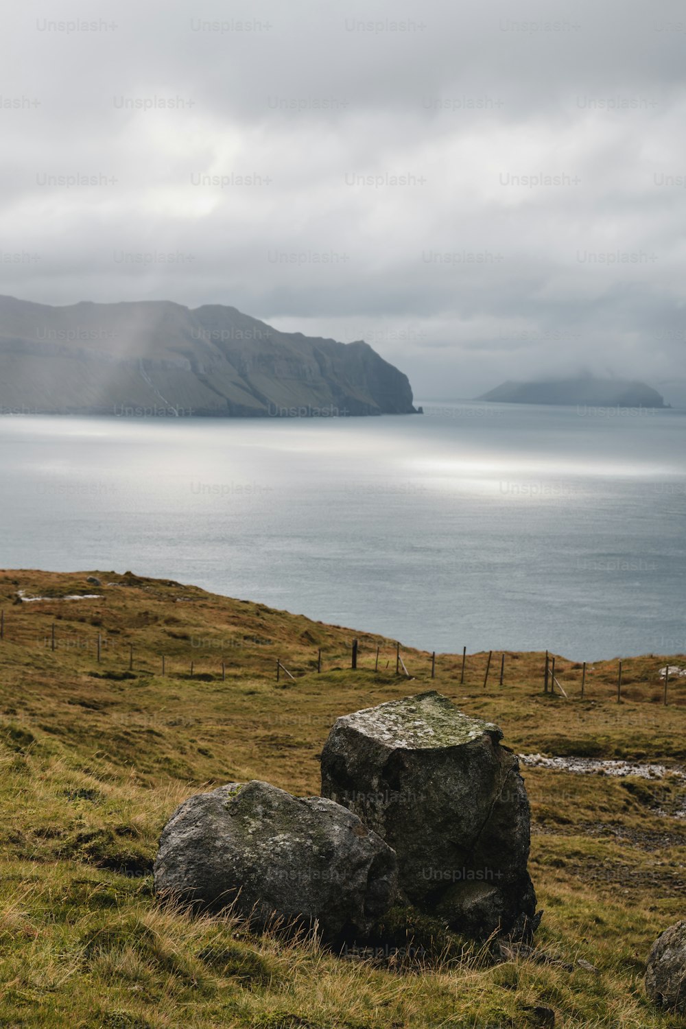 a large rock sitting on top of a lush green field