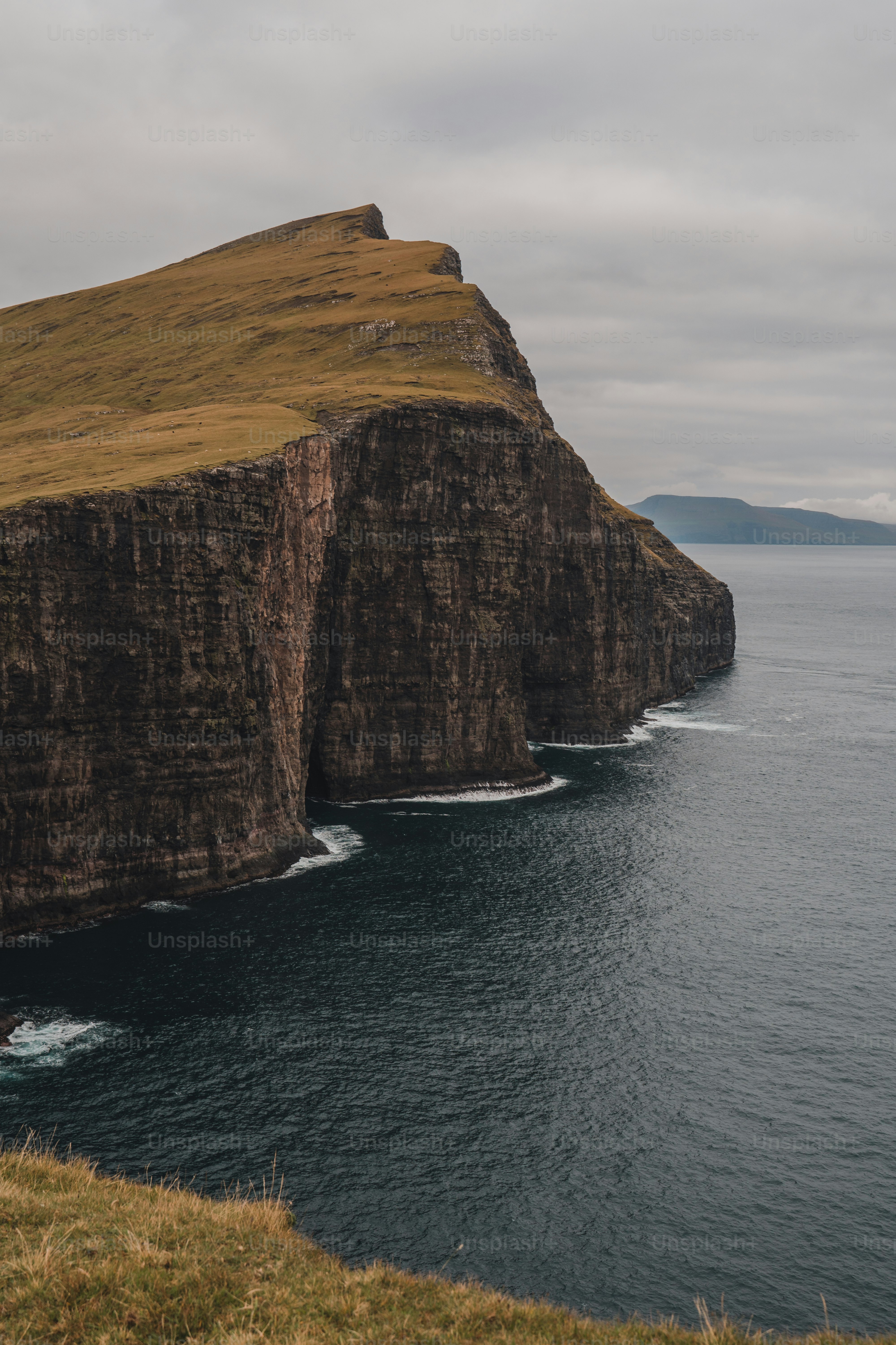 a large cliff on the side of a body of water