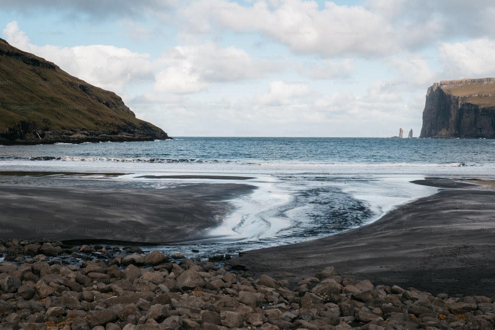 un grand plan d’eau assis à côté d’une plage rocheuse