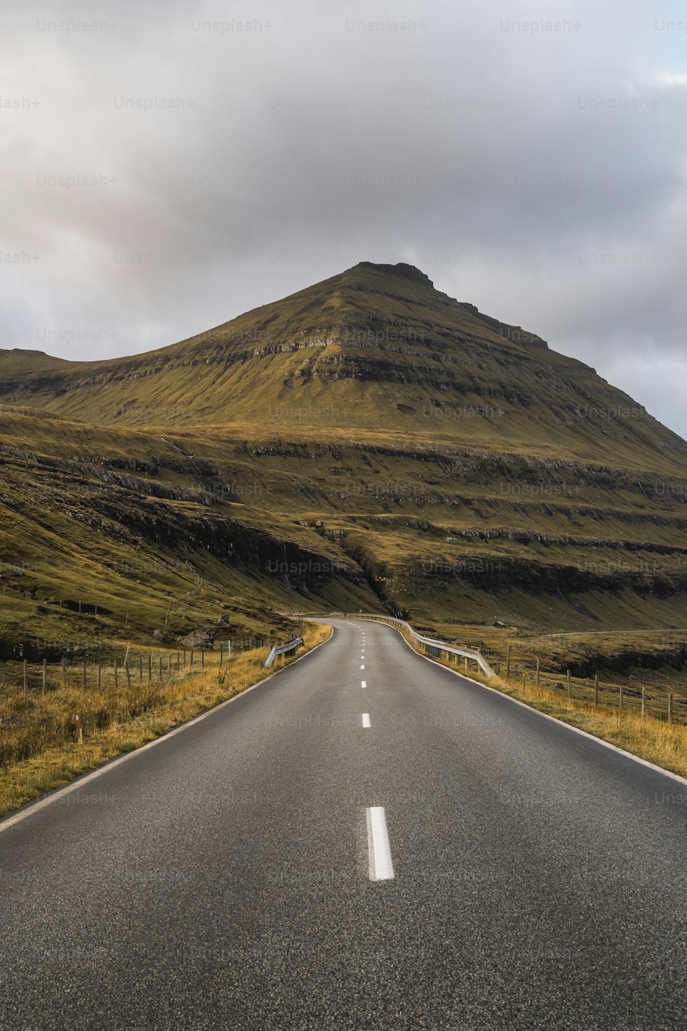 uma estrada vazia com uma montanha ao fundo