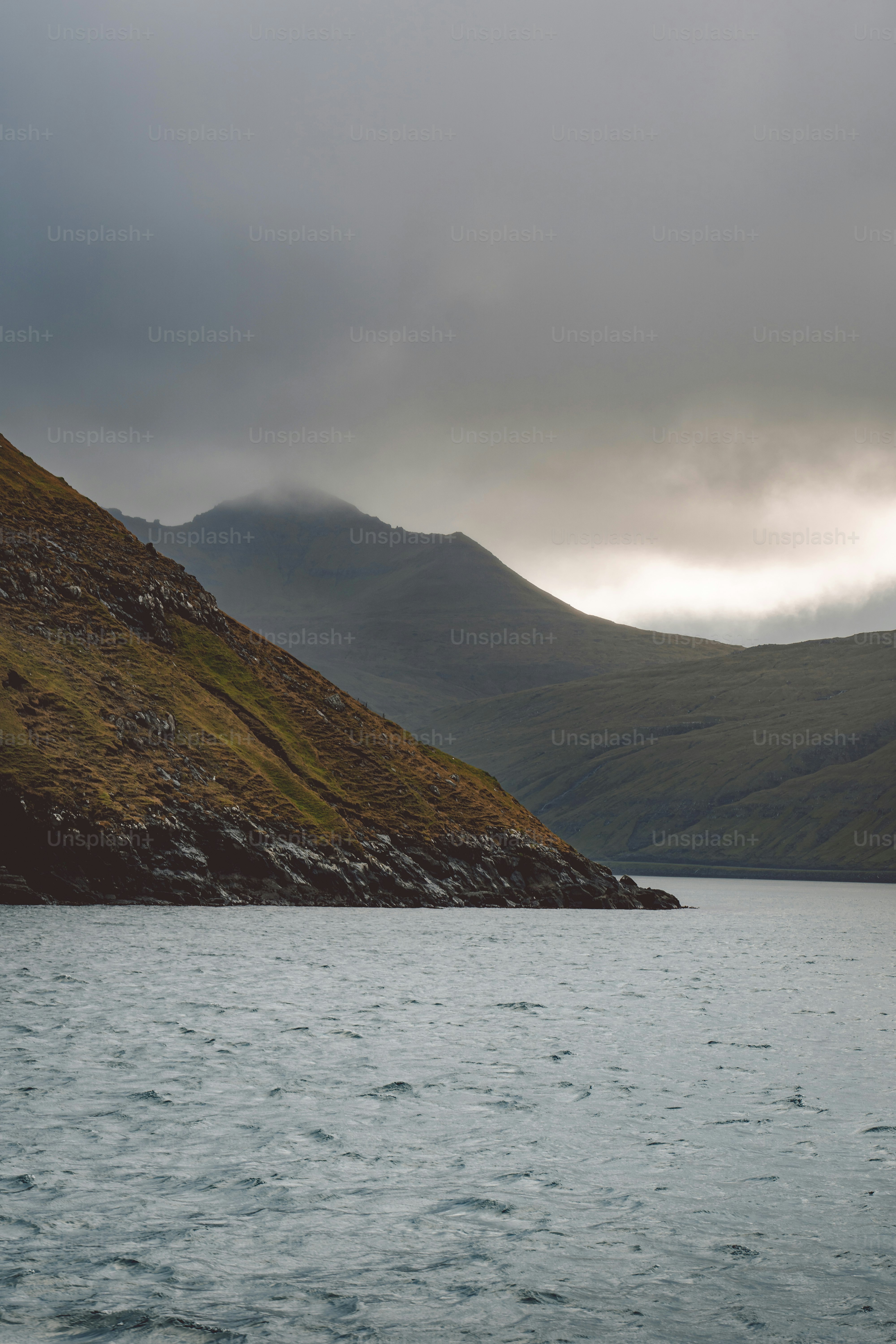 a large body of water with a mountain in the background