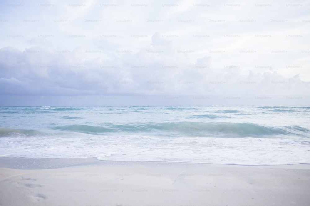 a sandy beach with waves coming in to shore