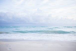 a sandy beach with waves coming in to shore