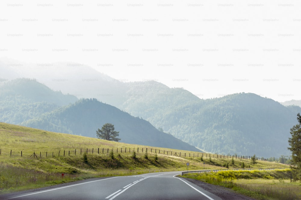 Une voiture roulant sur une route de campagne avec des montagnes en arrière-plan