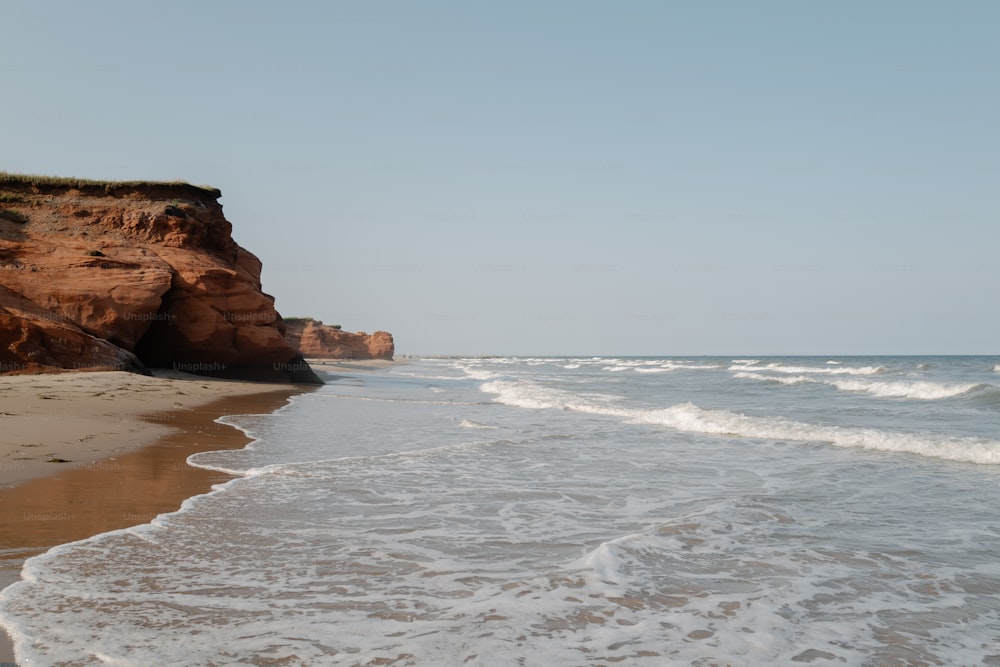 Una spiaggia sabbiosa accanto a una scogliera in una giornata limpida