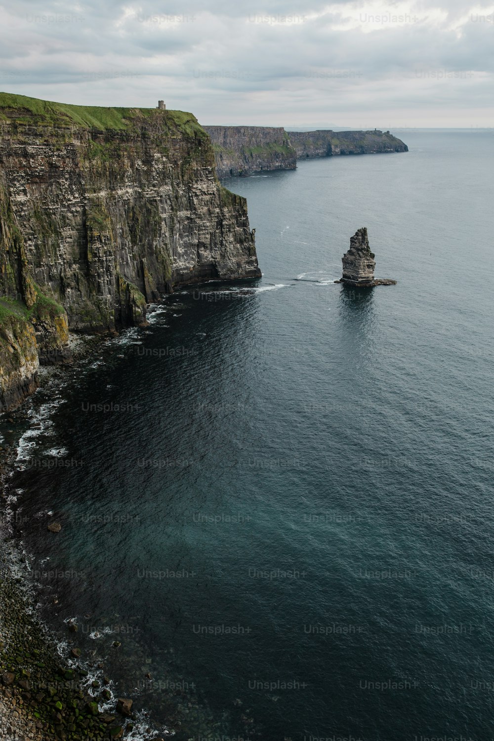 a boat is out on the water near a cliff