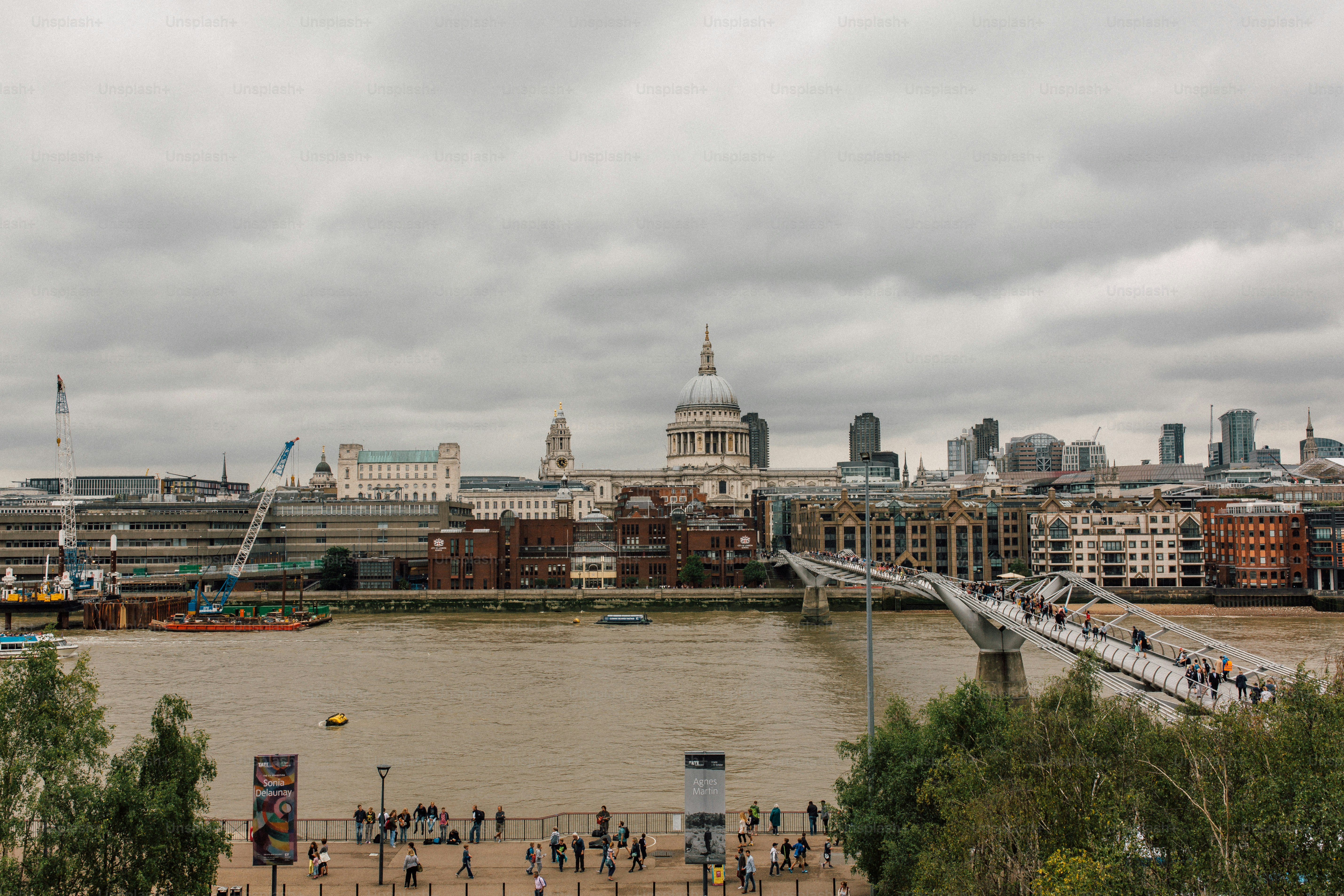 a group of people walking across a bridge over a river