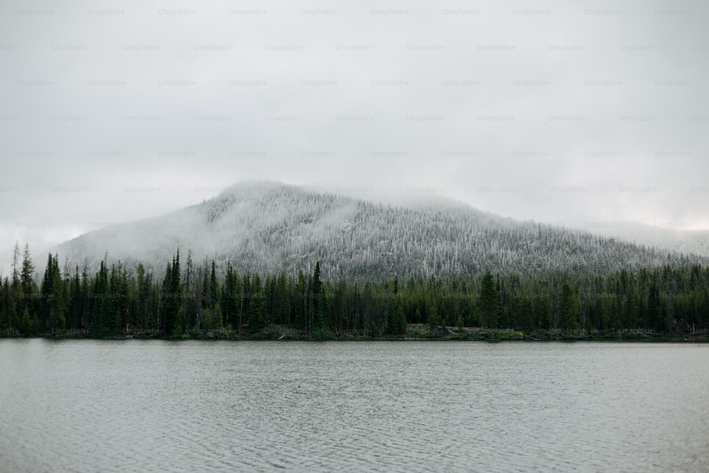 Ein schneebedeckter Berg neben einem See