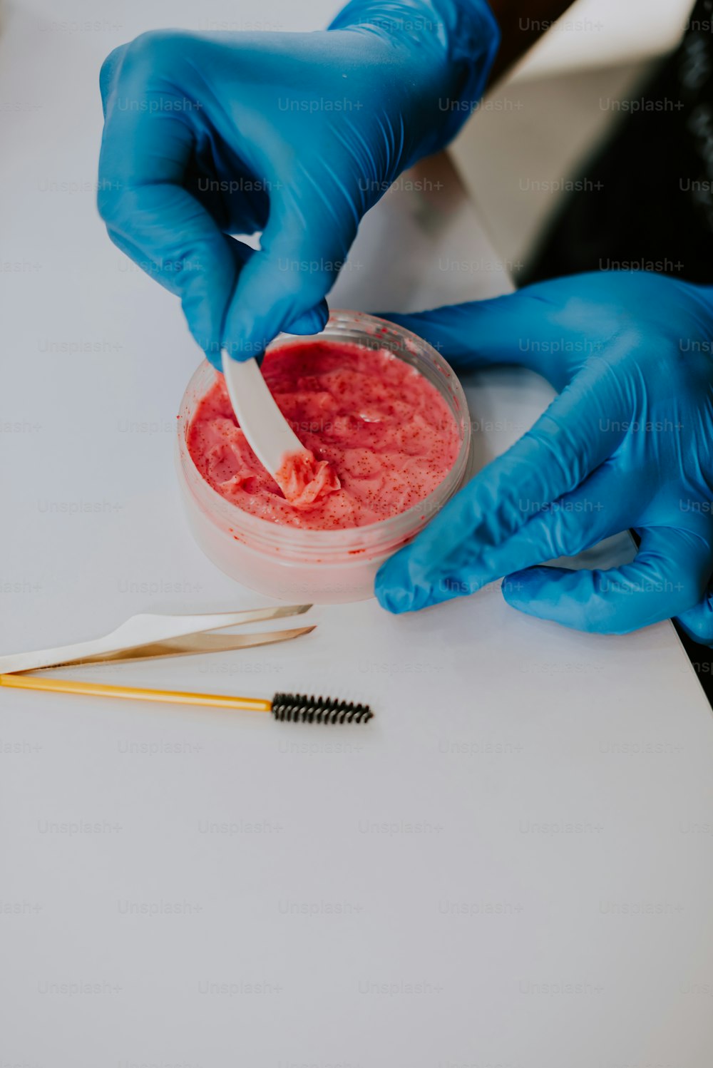 a person in blue gloves is putting something in a bowl