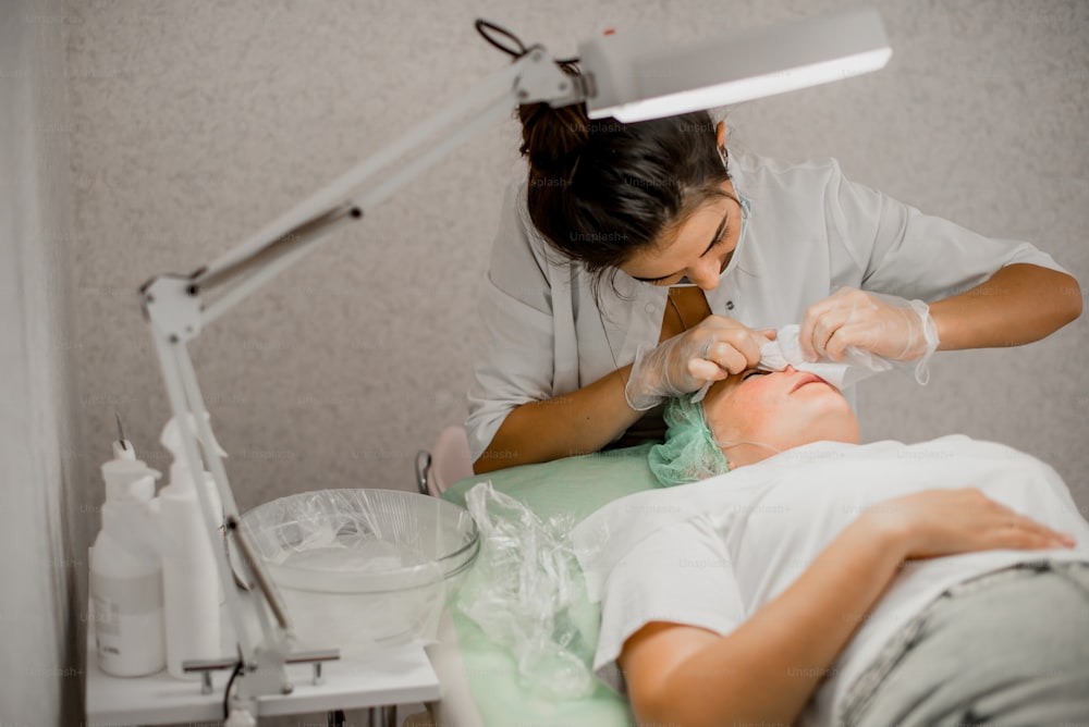Eine Frau, die ihre Zähne von einem Zahnarzt untersuchen lässt