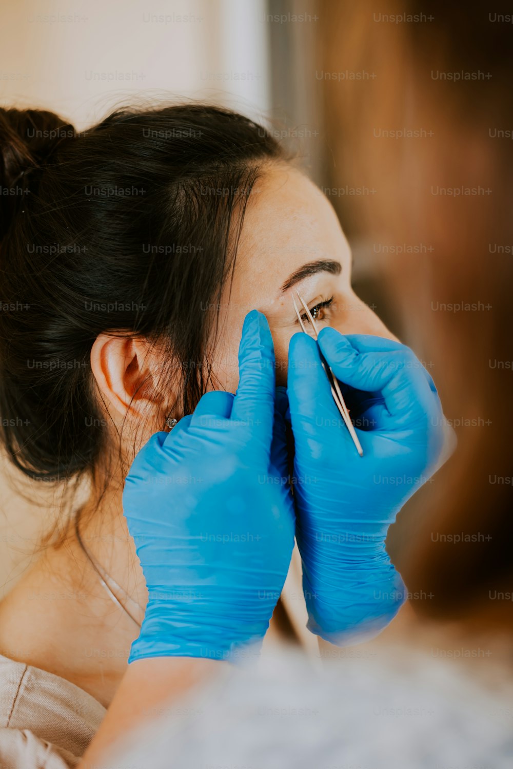 une femme se fait examiner les sourcils par un médecin