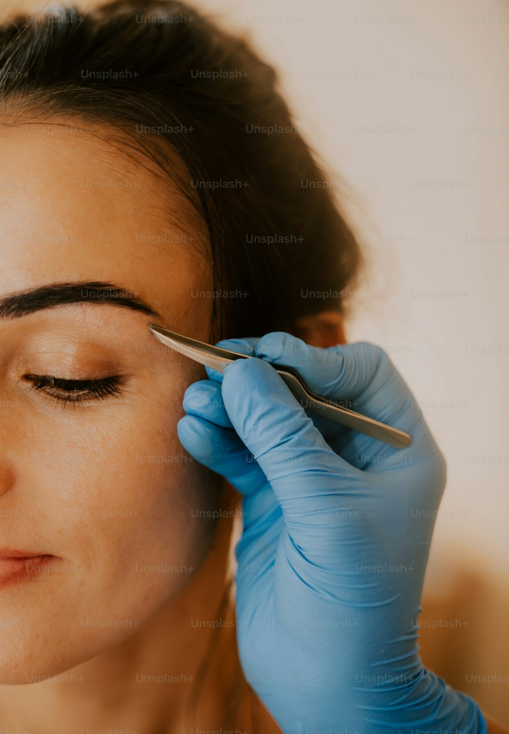 a woman getting her eyebrows done with a pair of scissors