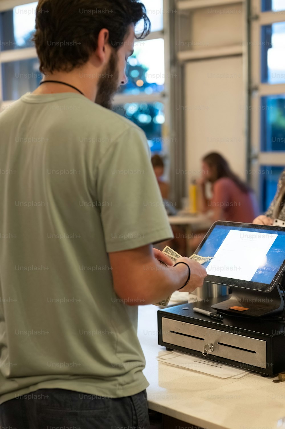 a man standing at a cash register in a store