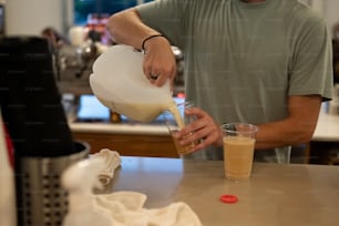 Un hombre vertiendo una bebida en un vaso