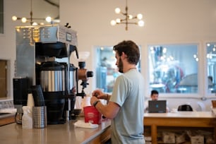喫茶店のコーヒーマシンで働く男性