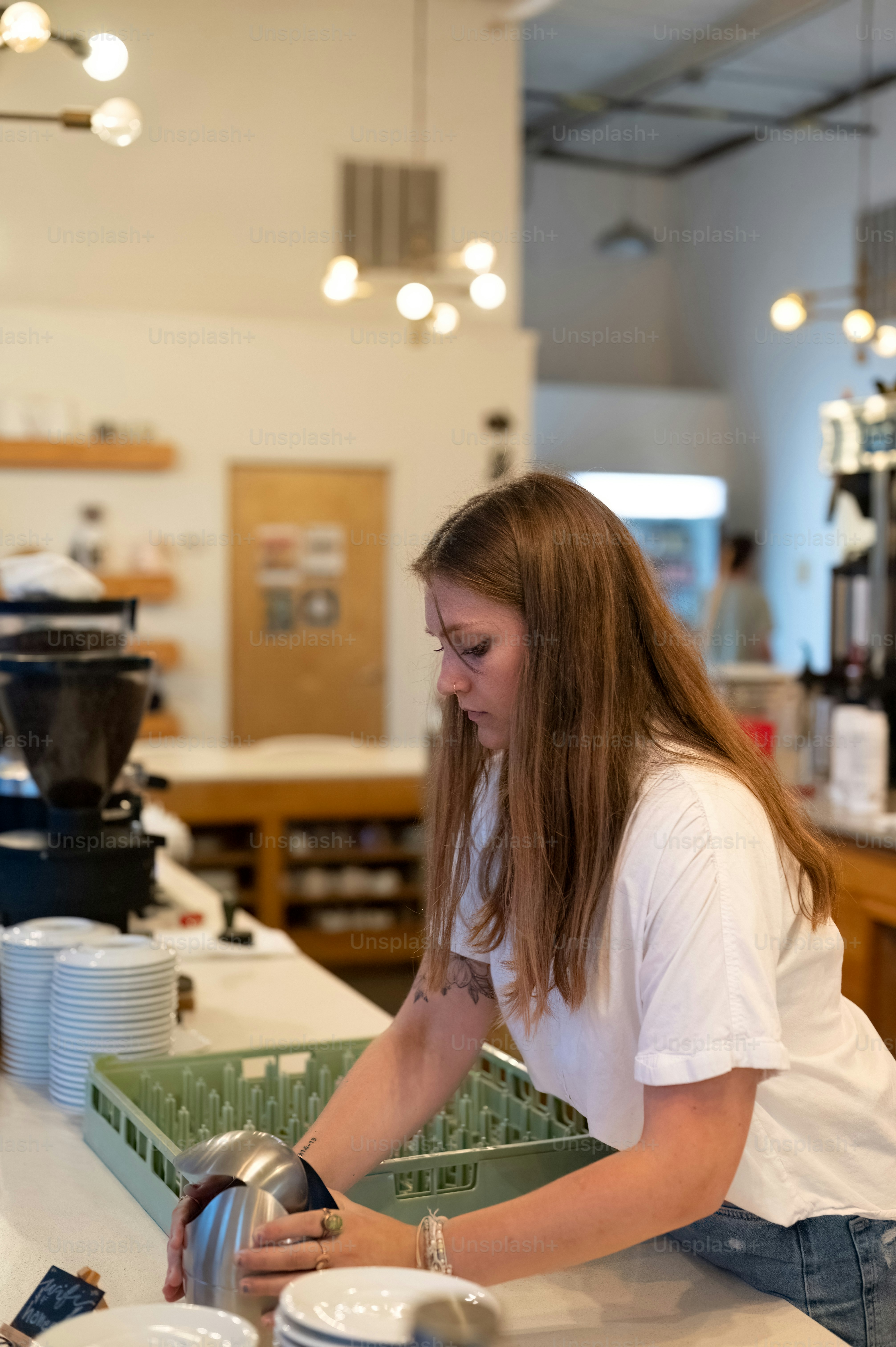 a woman is washing dishes in a kitchen