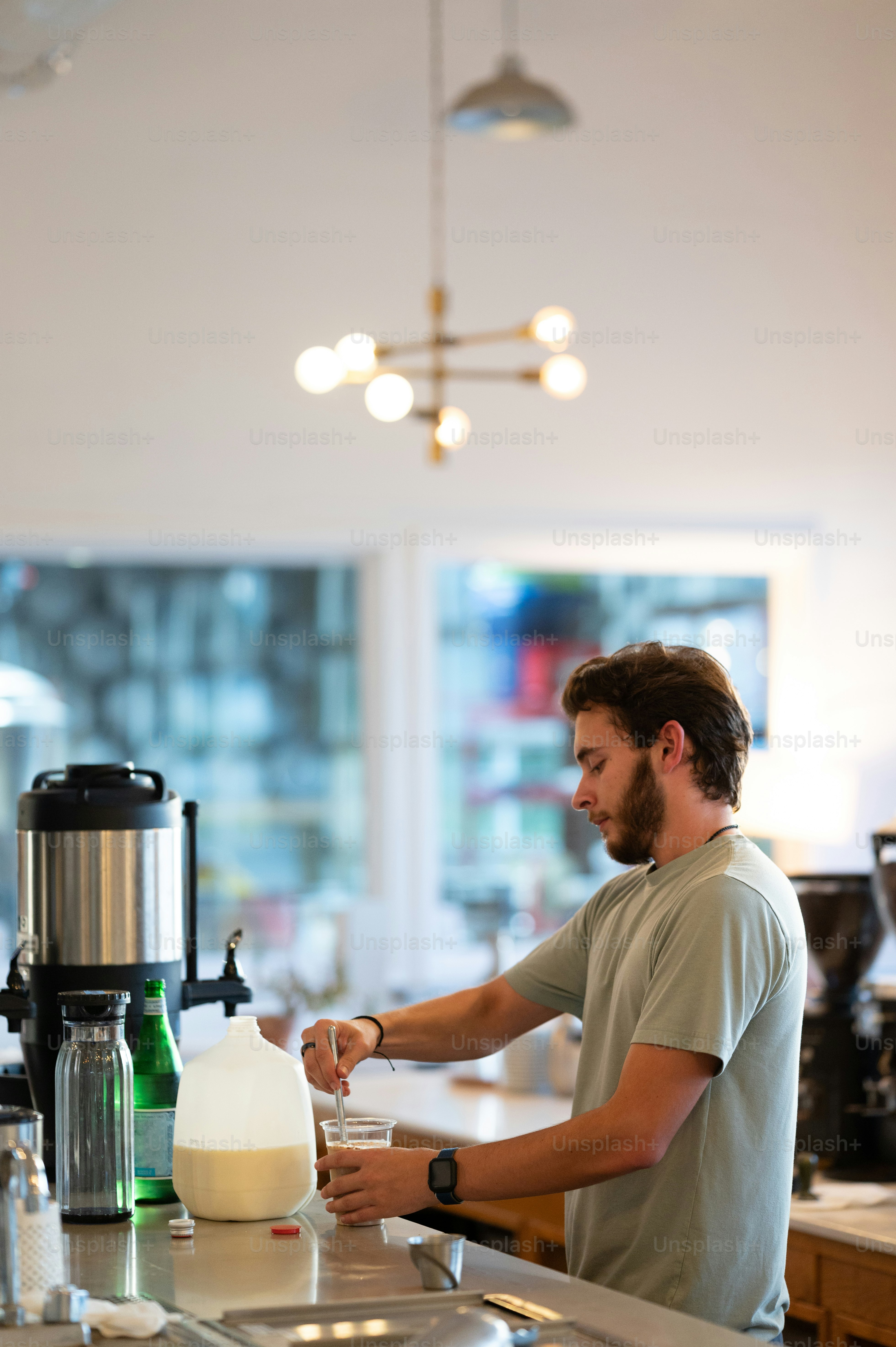 a man standing at a counter making a drink