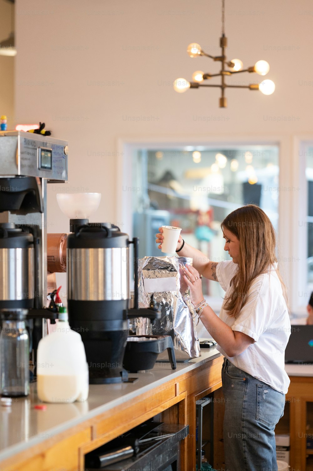 a woman pouring a cup of coffee in a coffee shop