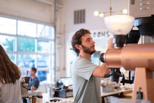 a man working on a coffee machine in a coffee shop