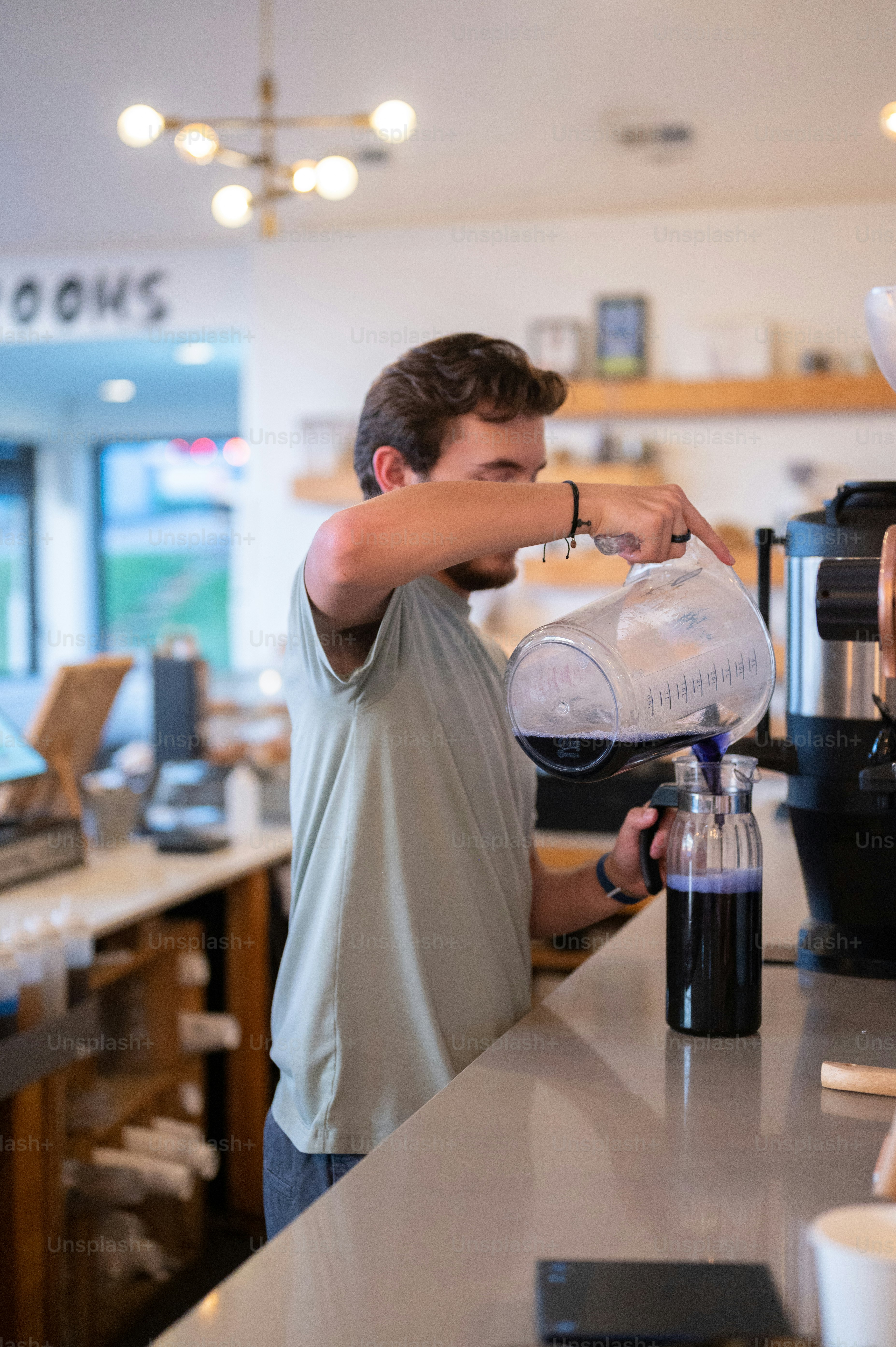 a man pouring a cup of coffee into a coffee maker