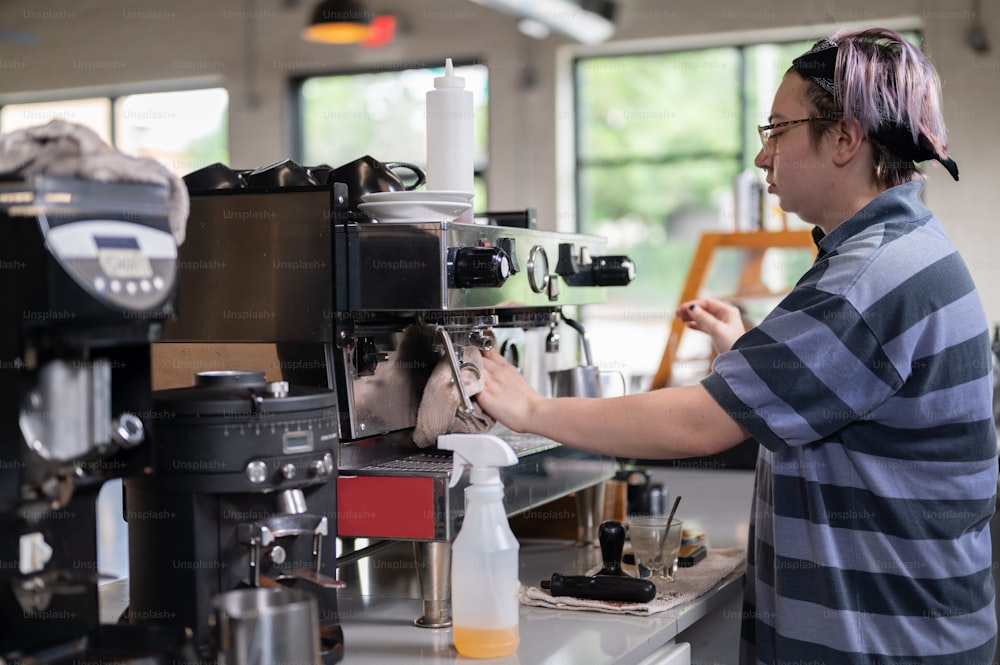Eine Frau arbeitet an einer Kaffeemaschine