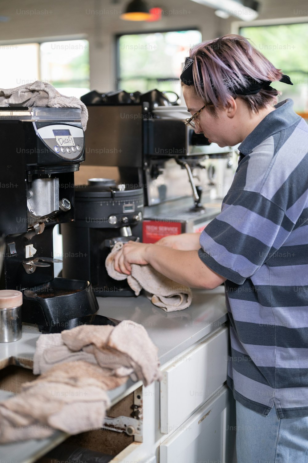Eine Frau, die an einer Kaffeemaschine in einem Café arbeitet