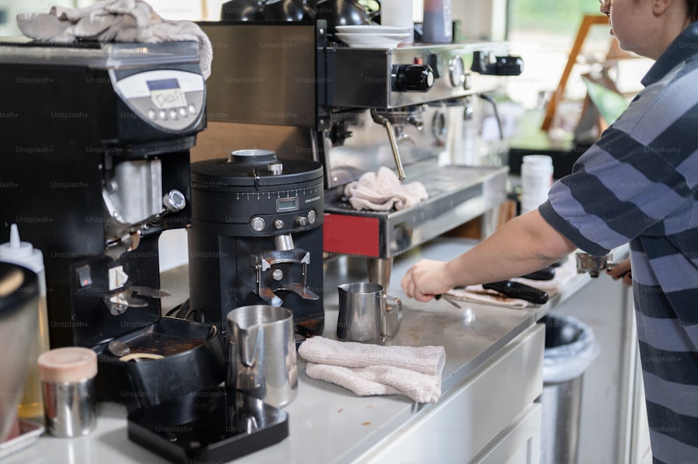 a person standing at a counter with a coffee maker