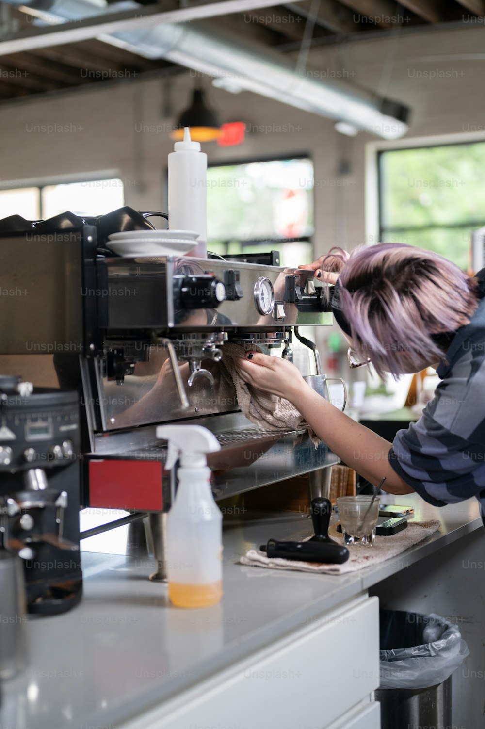 Una mujer está trabajando en una máquina de café
